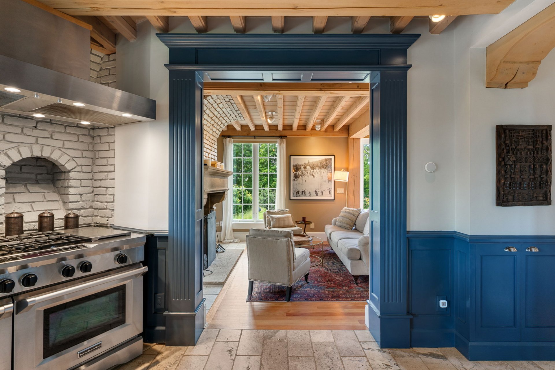 Blue painted archway between kitchen and living room with exposed beams