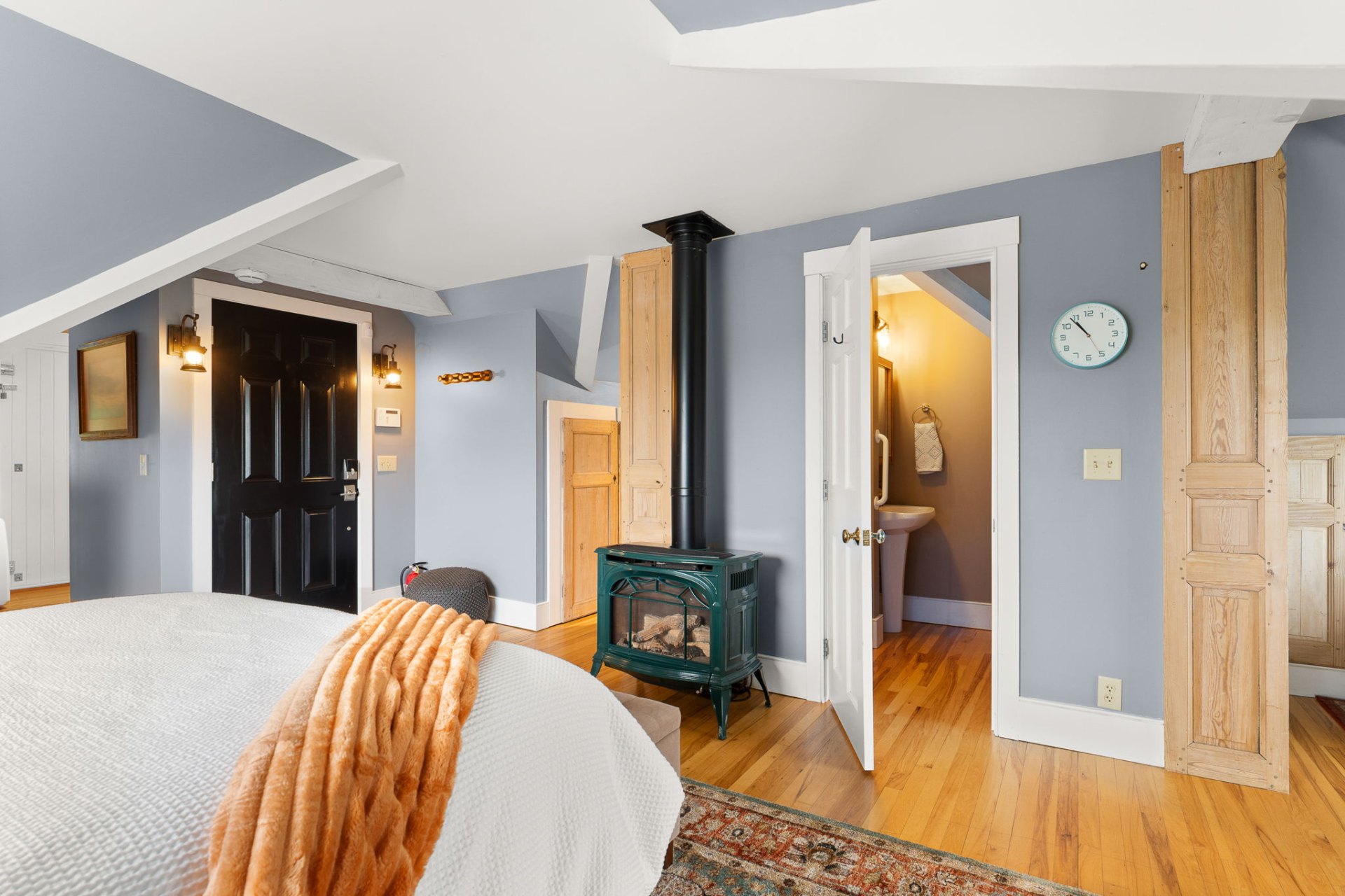 Carriage house bedroom with wood stove and soft blue walls